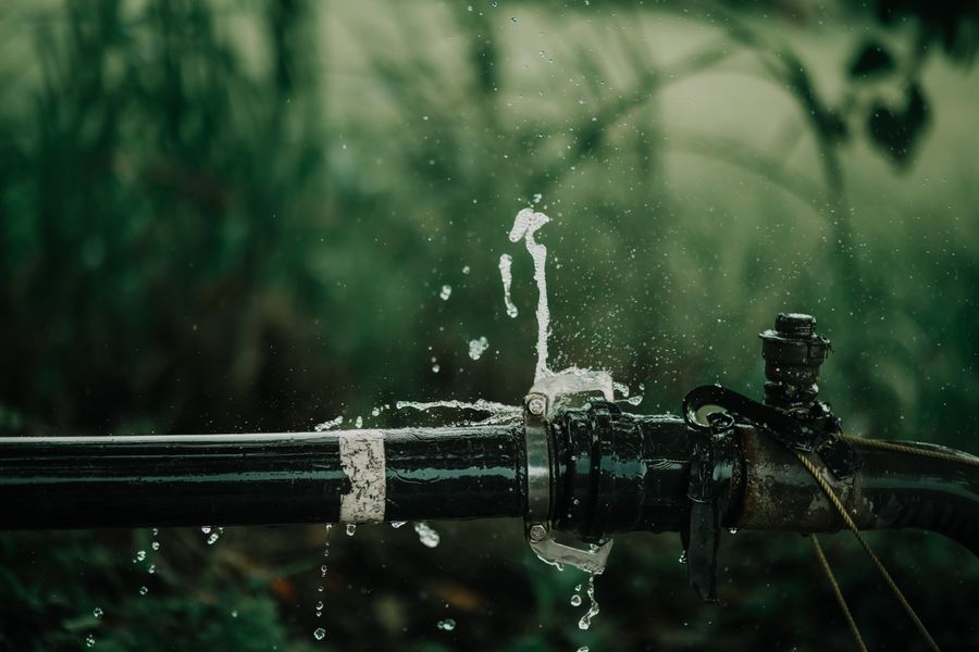 Water spraying from a leaking outdoor supply pipe