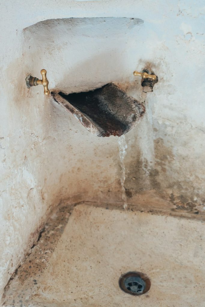 Old sink with a faucet dripping water