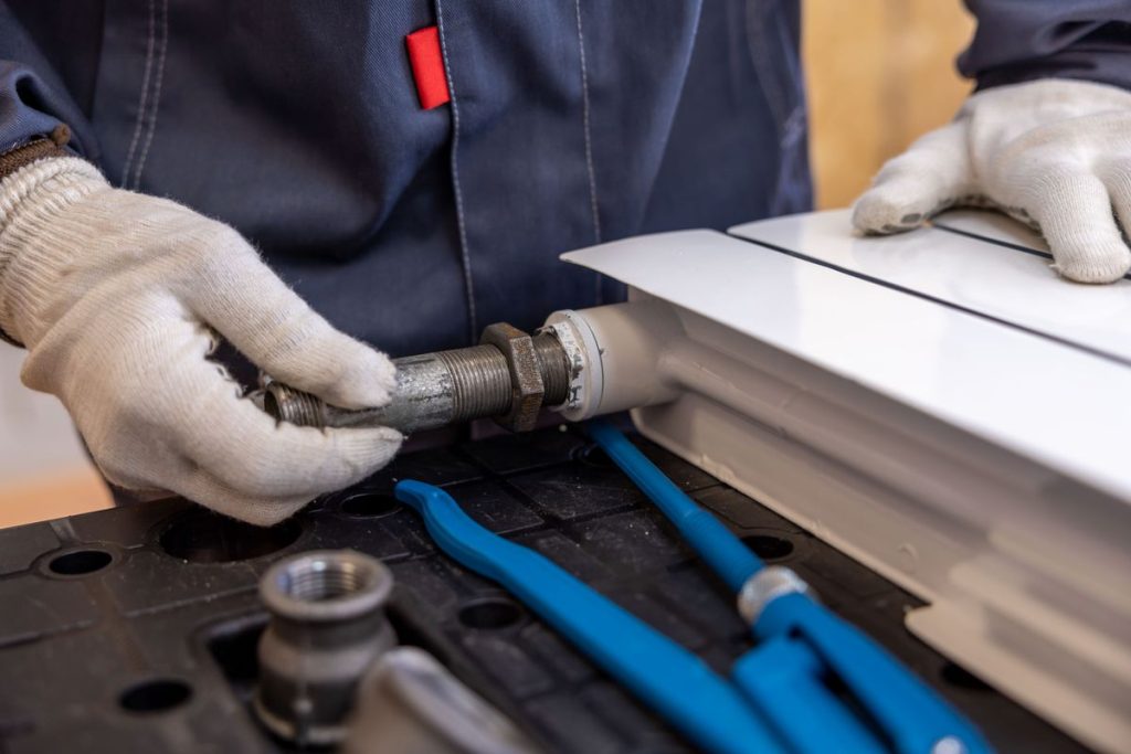 Plumber installing a pipe fitting with specialist tools