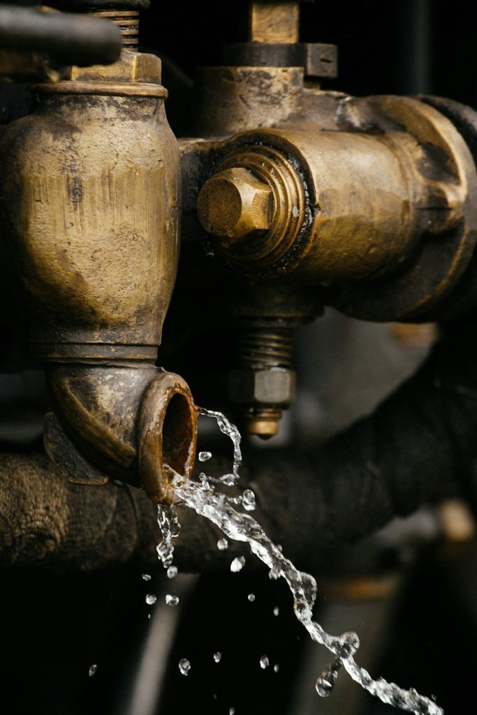 Water drop forming on a corroded brass pipe fitting