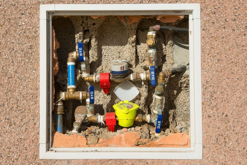 Water meter assembly installed in a wall recess